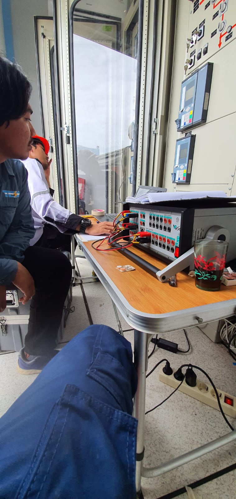 Sewa relay tester — teknisi PT TEM melakukan secondary injection test pada relay proteksi di panel kubikel switchgear